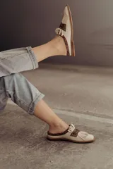 Zueco de cuero color crudo con detalle de flecos y pieza central en cuero snake.