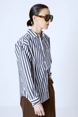 Camisa celeste con rayas verticales blancas, de corte clásico y manga larga.