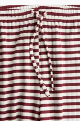 Pantalón de pierna amplia en punto suave a rayas horizontales color borgoña y blanco. Modelo con elástico revestido y cordón para ajustar en la cintura.