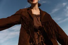 Chaqueta marrón de gamuza con flecos en la parte delantera y trasera.