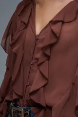 Camisa marrón con volados, de mangas largas y corte holgado.