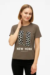 Remera negra de algodón con cuello en V y estampado frontal con la frase "Never Stop Me" en letras doradas y plateadas con estrellas.
