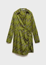 Vestido corto de tejido fluido color verde con estampado abstracto en blanco y negro. Diseño cruzado con cuello camisero, mangas largas y cierre de lazo lateral.
