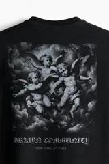 Remera negra de algodón con cuello redondo ribeteado acanalado, hombros caídos, diseño estampado con texto "New York, NY 11201" y bajo recto.