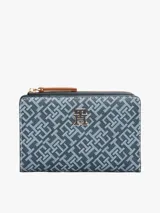 Billetera plegable Tommy Hilfiger con estampado integral, múltiples ranuras para tarjetas, compartimento para billetes, bolsillo exterior con cremallera y logo TH en la parte delantera.