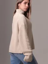 Sweater color beige de tejido de punto grueso con cuello alto y corte relajado.