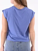 Remera azul de corte recto, con cuello redondo y mangas cortas con hombreras.