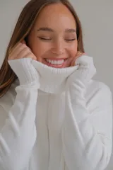 Sweater blanco de corte recto con cuello alto y aberturas laterales.
