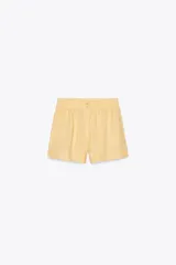 Shorts de tiro medio confeccionados en lino 100%. Cuentan con bolsillos laterales ocultos en la costura, bolsillos de parche en la parte trasera, cintura elástica, aberturas laterales en el bajo y cierre frontal con botones.