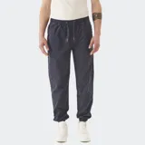 Pantalón jogger azul de gabardina con puño en el ruedo y pretina ajustable.