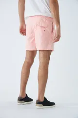 Short de baño azul con estampado de hojas y flores en blanco. Tiene cintura elástica con cordón ajustable, dos bolsillos laterales y uno trasero.