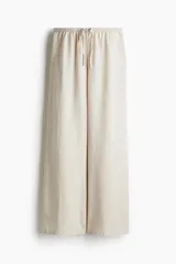 Pantalón de lino color crudo, de corte amplio, con cintura elastizada y cordón de ajuste.