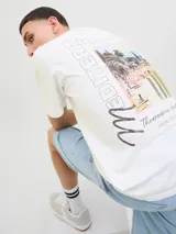 Remera blanca de algodón con cuello redondo y manga corta. Estampado en el frente con imagen de playa y texto "Mediterranean Works, The Creative Studio, Jack & Jones".