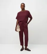 Pantalón femenino de corte fluido, color rojo vibrante, con cintura elástica ajustable mediante lazo y bolsillos laterales.