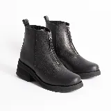 Botas de cuero negro con caña corta, suela track y cremallera frontal.