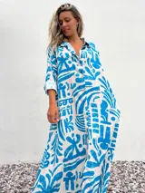 Vestido camisero largo de corte amplio, con estampado abstracto en tonos celeste y crudo.
