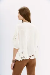 Blusa blanca de viscosa con escote en V, mangas 3/4 con detalle de encaje y pinzas verticales en el frente.