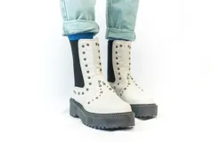 Bota Chelsea color crema con plataforma track negra y elásticos laterales con tachas plateadas.