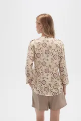 Camisa de viscosa con estampado floral en tonos azul, beige y blanco. Tiene cuello mao, mangas largas y bolsillos en el pecho.
