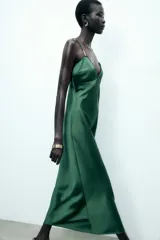 Vestido midi verde esmeralda de satén, con escote en pico, tirantes finos regulables con apliques dorados y cierre lateral con cremallera oculta.