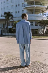 Camisa celeste a rayas verticales blancas, de manga larga, con cuello clásico y corte comfort.