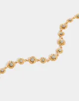 Collar corto dorado con cadena de eslabones y flores con centro plateado.