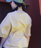 Remera color arena con cuello redondo y estampado frontal con letras "MTPE" en marrón.