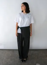 Minifalda negra para usar sobre pantalones, con lazos laterales para atar.