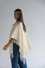 Ruana color crudo con flecos en el ruedo.