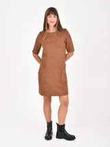 Vestido corto color marrón, de manga corta, cuello redondo y dos bolsillos delanteros cuadrados.