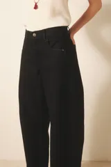 Pantalón jean negro de tiro medio y calce holgado, confeccionado en denim rígido con lavado suavizado.