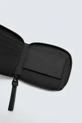 Billetera negra con acabado engomado, múltiples ranuras para tarjetas y billetes, y monedero con cierre de botón a presión.