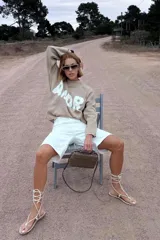 Bermuda blanca de tiro alto, corte recto y largo hasta la rodilla.