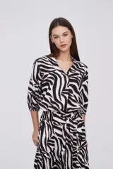 Blusa color beige con estampado abstracto en tonos marrones, de viscosa, corte al cuerpo y cuello en V.