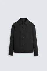 Sobrecamisa negra de algodón con cuello solapa, manga larga con puños abotonados, bolsillos de parche en el pecho y cierre frontal con botones. Corte relaxed fit.