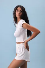 Conjunto de pijama color beige, compuesto por un top de mangas cortas con ribete marrón y shorts con ribete marrón.