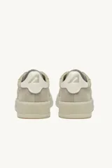 Championes Autry modelo Dallas Low, color beige confeccionados en gamuza con detalles en cuero blanco en el talón y logo de la marca en el lateral.