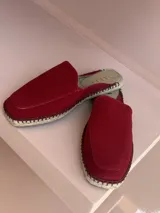 Zuecos color rojo con capellada de gamuza, plantilla acolchada y suela de yute.