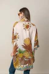 Camisa italiana de viscosa estampada con diseño abstracto en tonos azul, amarillo y verde sobre fondo natural, de corte irregular y mangas 3/4.