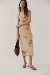 Vestido midi color crema con breteles finos, escote en V con encaje y bordado de flores rosas. Falda con terminación en encaje. Incluye forro.