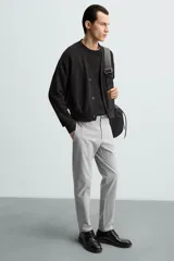 Pantalón largo de vestir gris claro con estampado de cuadros, corte slim fit y cintura elástica. Confeccionado en tejido con alta elasticidad, bolsillos frontales y cierre frontal con cremallera y botón.