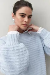Sweater negro tramado de silueta relajada, con combinación de texturas en el tejido y mangas abullonadas con puños elastizados.