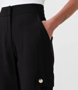 Pantalón zanahoria negro de viscosa, con cintura alta, bolsillos cargo con botón dorado y ruedo con dobladillo. 