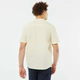 Camisa de lino color amarillo claro, de corte recto, con cuello mao, manga corta con dobladillo y cierre frontal con botones.