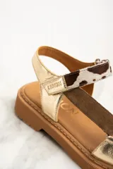Sandalia de cuero color dorado con tiras marrón y estampado animal print, con plataforma marrón.