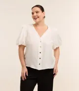 Blusa blanca de crepé con escote en V, abotonada en el frente y mangas cortas abullonadas.