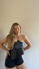 Top negro de ecocuero con textura simil piel de cocodrilo, corte irregular y cuello halter con aro metálico.