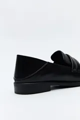 Mocasín negro de cuero sintético con punta cuadrada y detalle de bordado a tono en la capellada. Taco de 2,5cm.