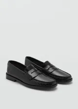 Zapato negro de cuero tipo mocasín con suela plana, diseño clásico y elegante.