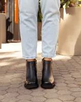 Botinetas de cuero negro con diseño de punta cuadrada y taco bloque. Presentan cierre lateral para facilitar el calce y una textura sutil en la puntera.